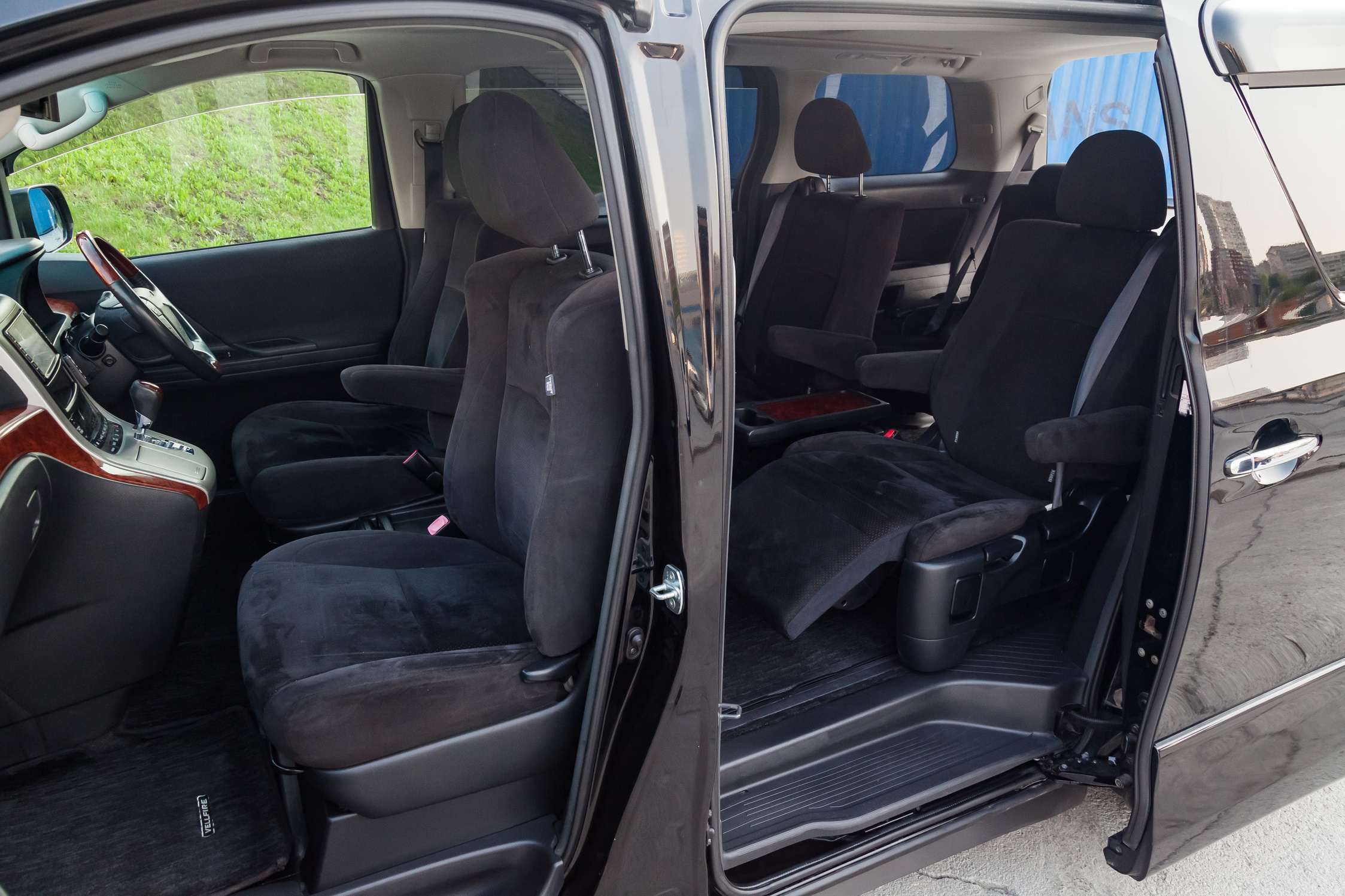 japanese luxury minivan car interior view through the opened doors with seven passenger seats